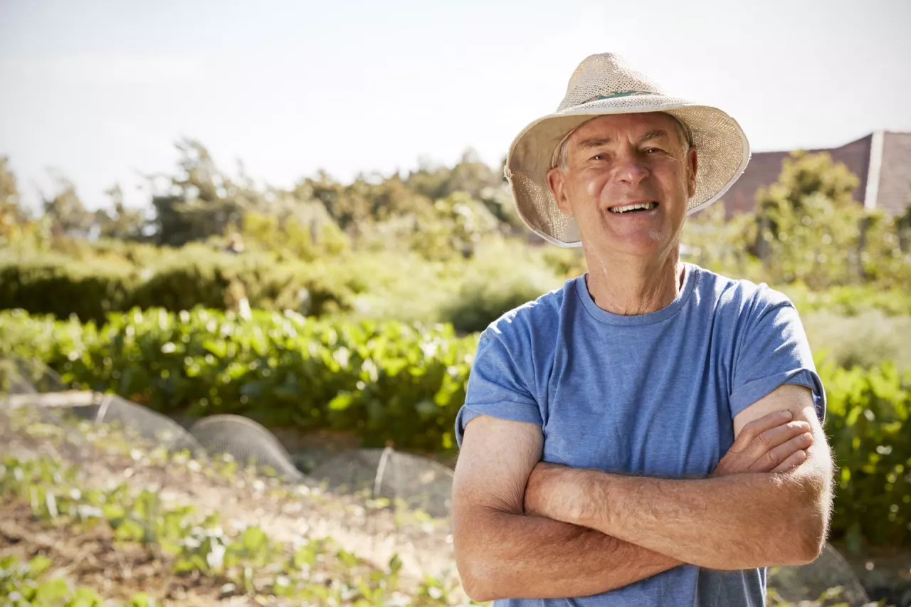 Portrait Of Mature Man Standing On Allotment