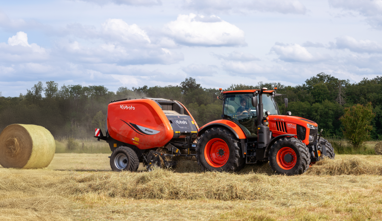 ciągnik Kubota na polu z zaczepioną prasoowijarką