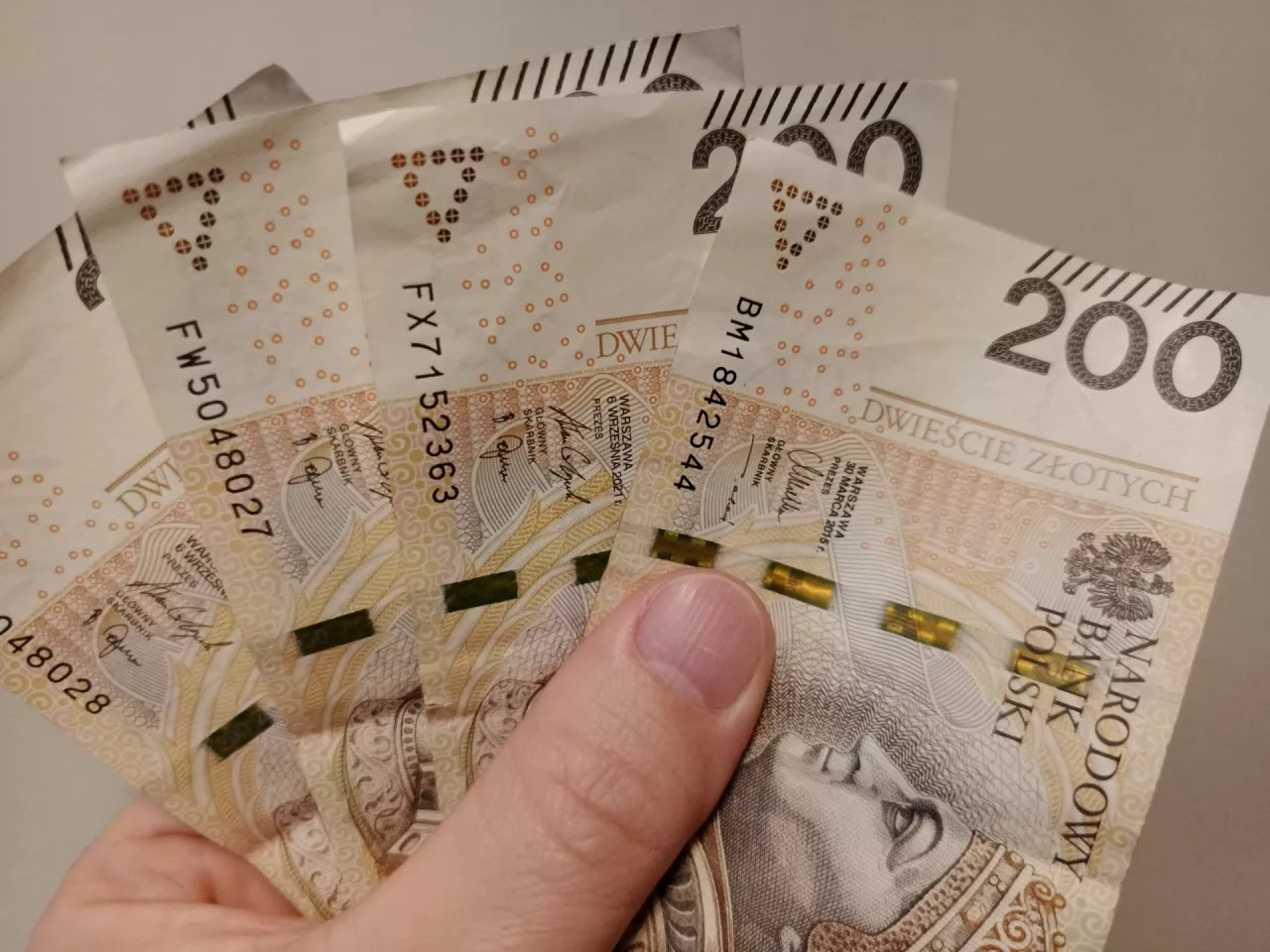polskie banknoty w dłoni